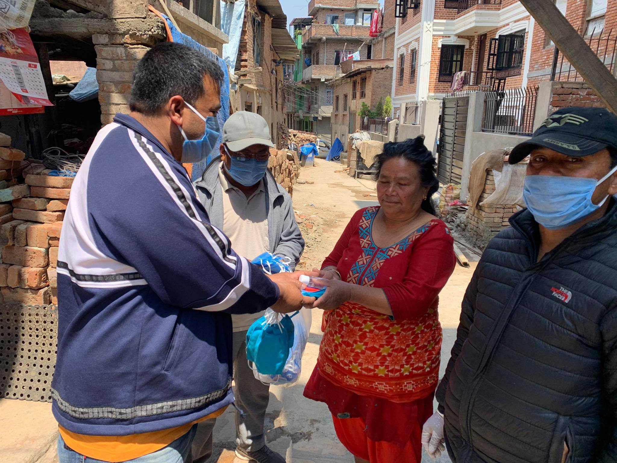 Local officials in Nepal hand out masks to protect against COVID-19 made by local handicraft workers ©UN-Habitat