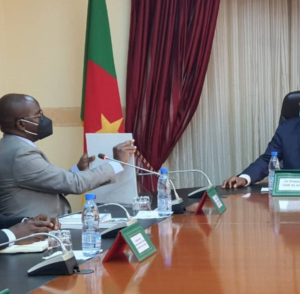 UN-Habitat's Deputy Executive Director, on a two day visit to Cameroon, presents a copy of UN-Habitat's Catalogue of products and services to Prime Minister, Dion Ngute.