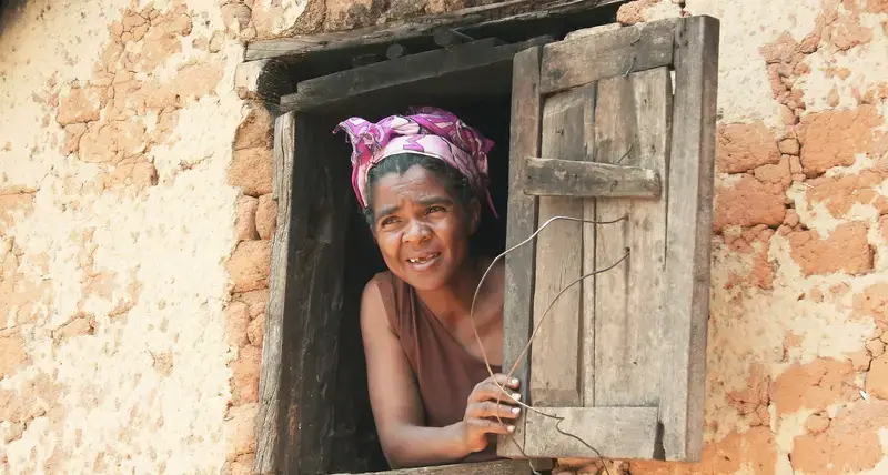 A woman peeps through a window in Madagascar. 2008.