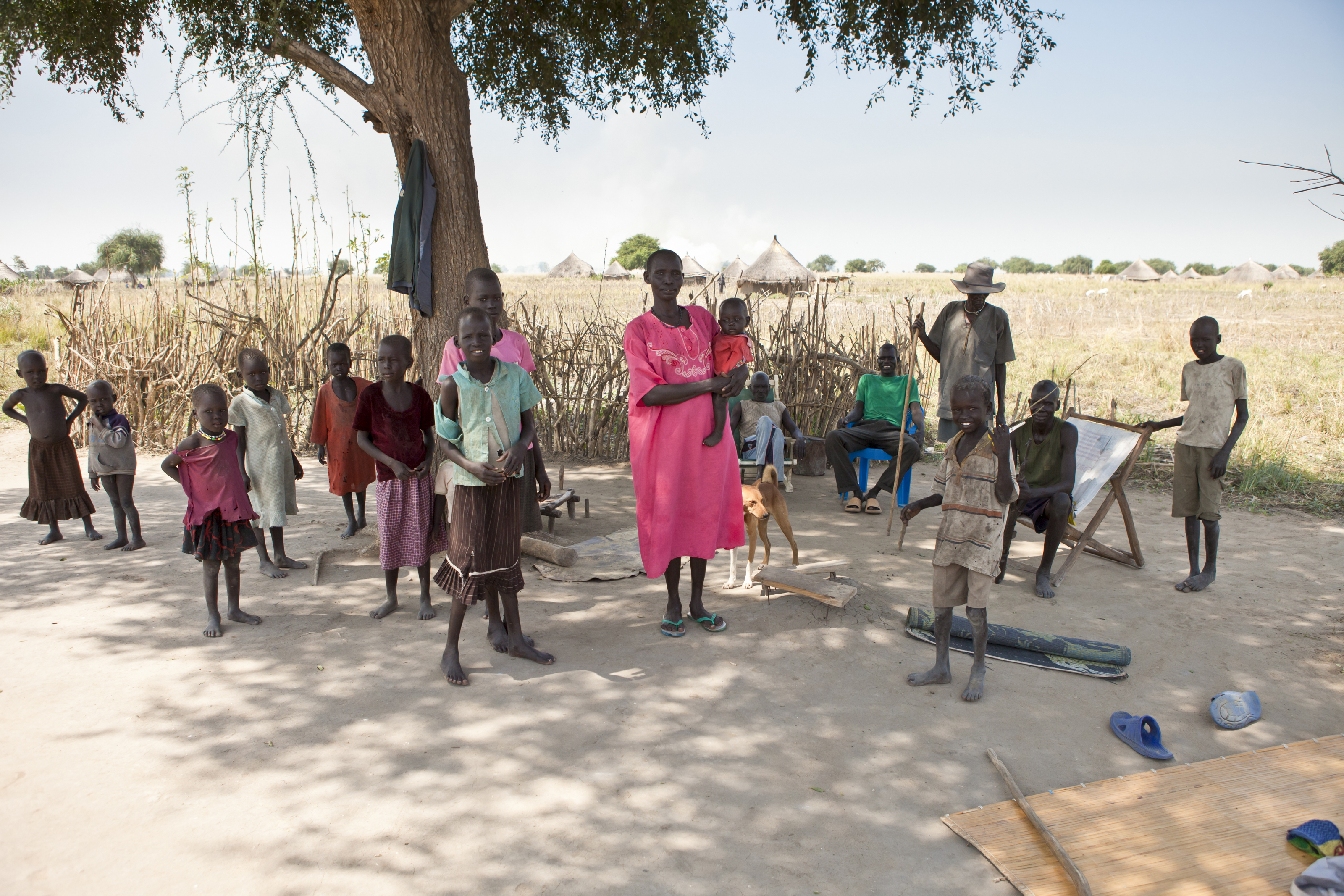 A family stands in the shade of a tree in Liliir, South Sudan.
