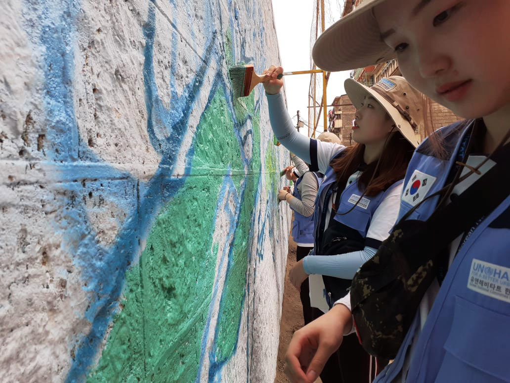 A Korean visitor painting the mural in Mathare.