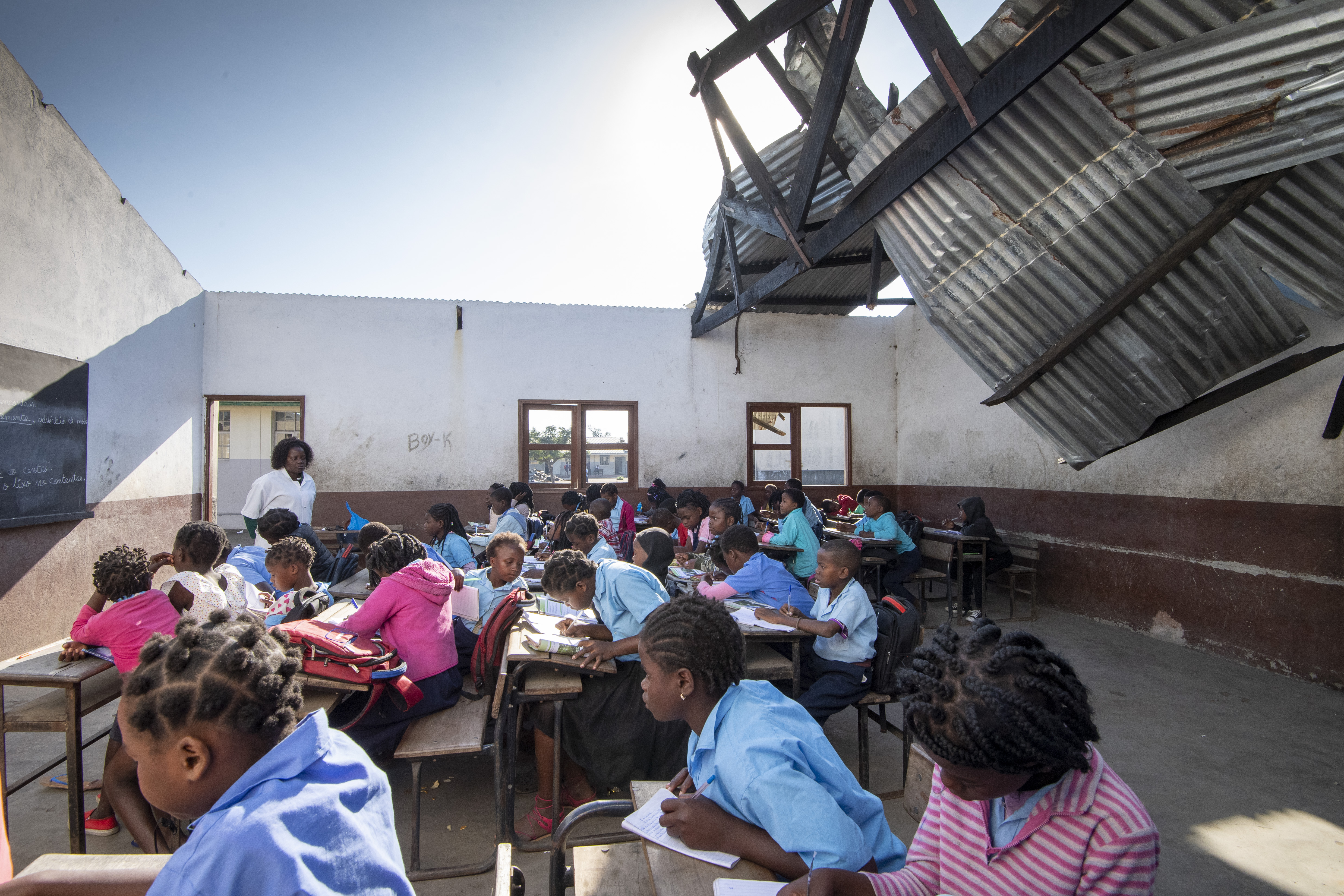 Children learn in a school with no roof