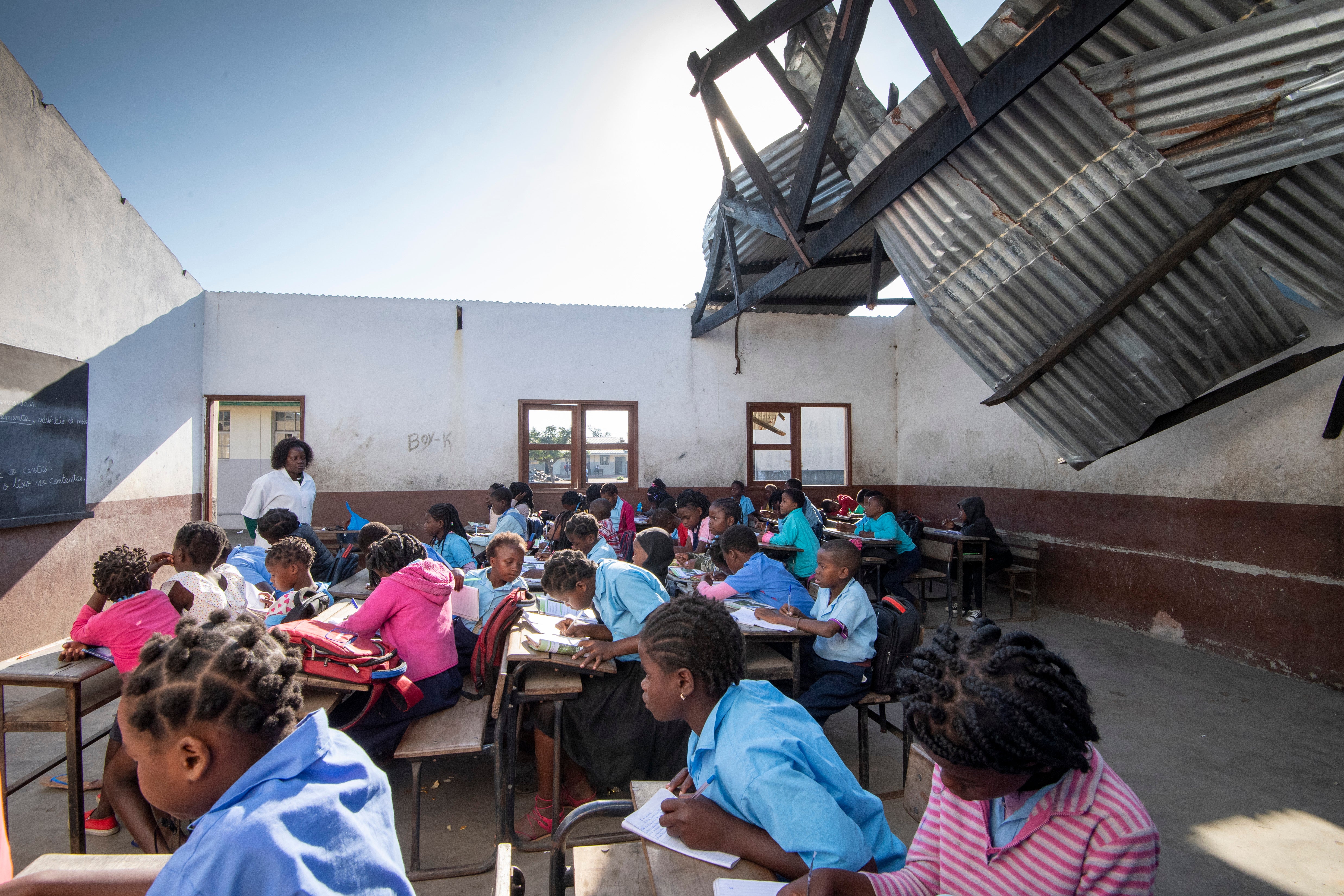 Children learn in a school with no roof