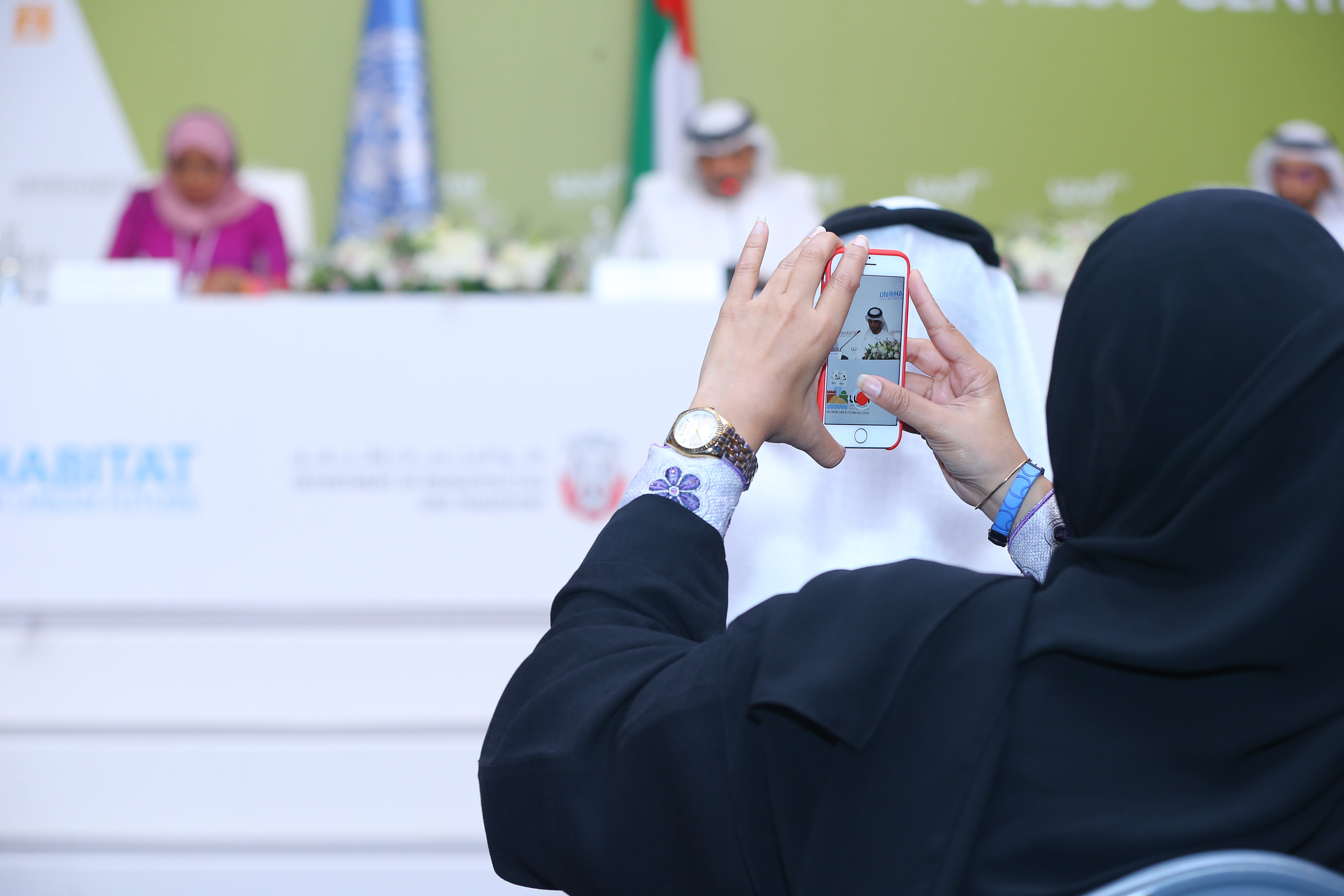 A woman takes a photo at the press confernce