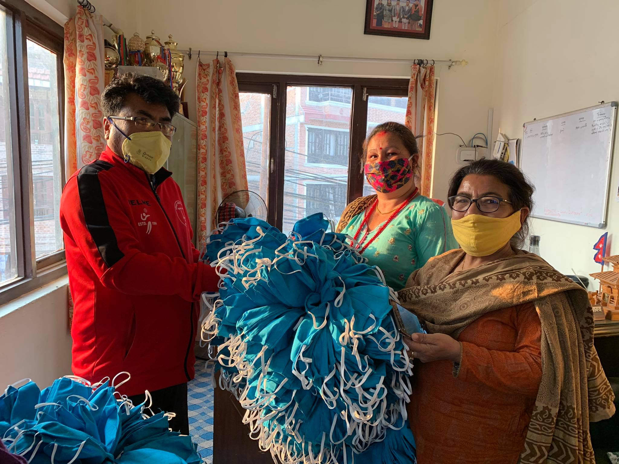 Local officials in Nepal hand out masks and sanitizer to protect against COVID-19 made by local handicraft workers 