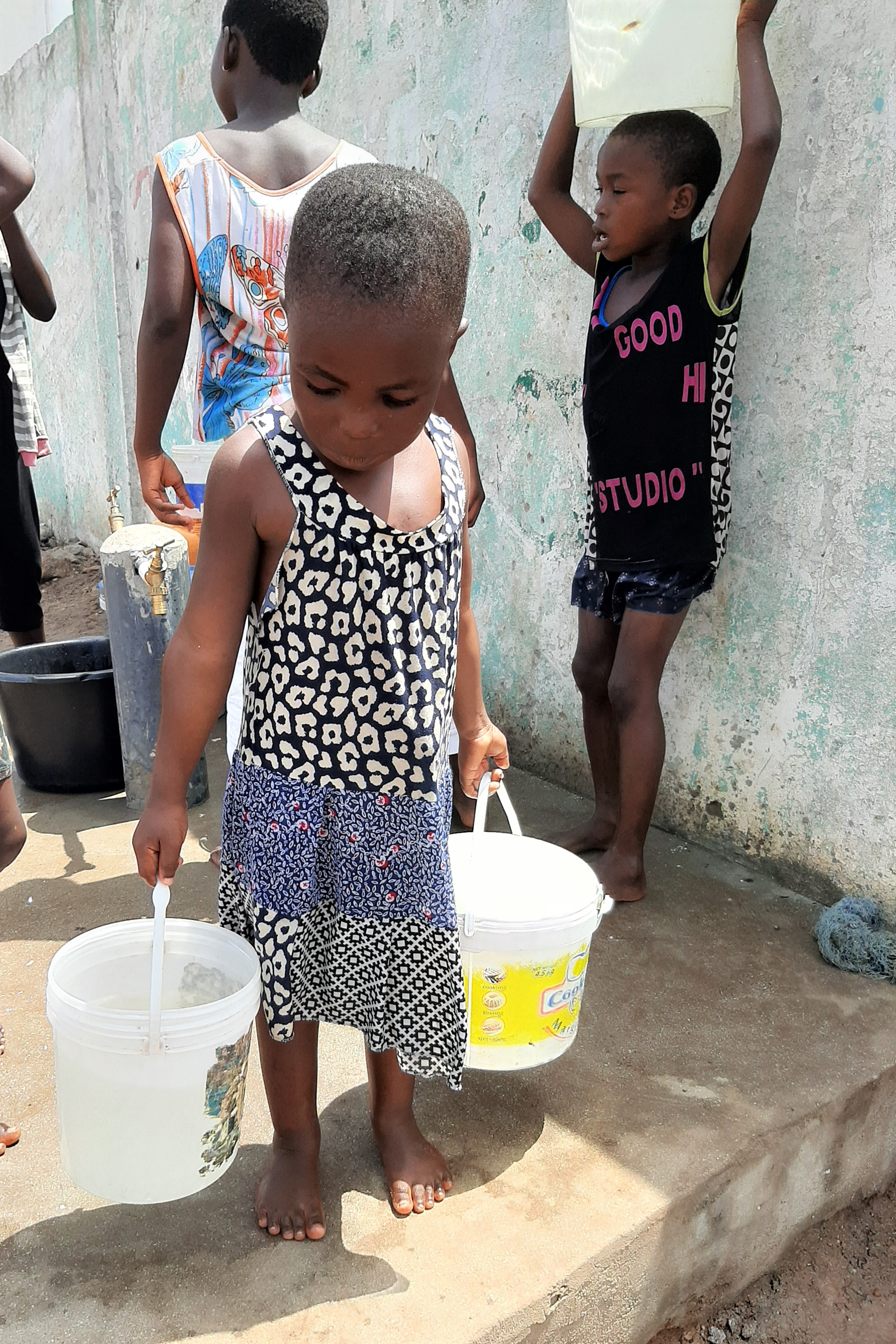 A child brings water from one of the stand pipes constructed in the Gamashie community in Accra, Ghana as part of provision of water and other COVID-19 prevention measures provided by UN-Habitat