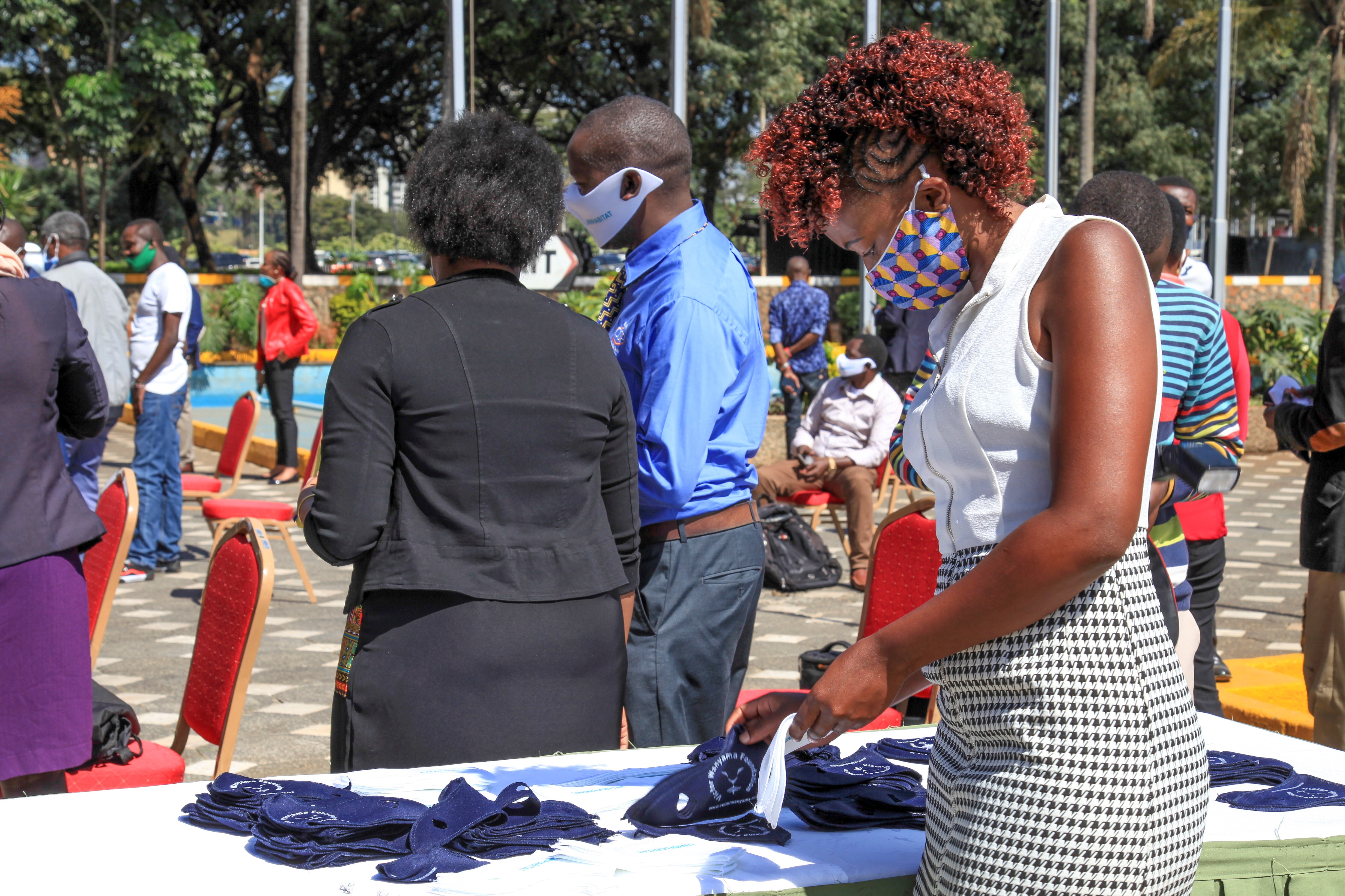 A participant in the launch of the  second response phase to COVID-19 in Kenya looks at masks being distributed by UN-Habitat UNHabitat/Julius Mwelu