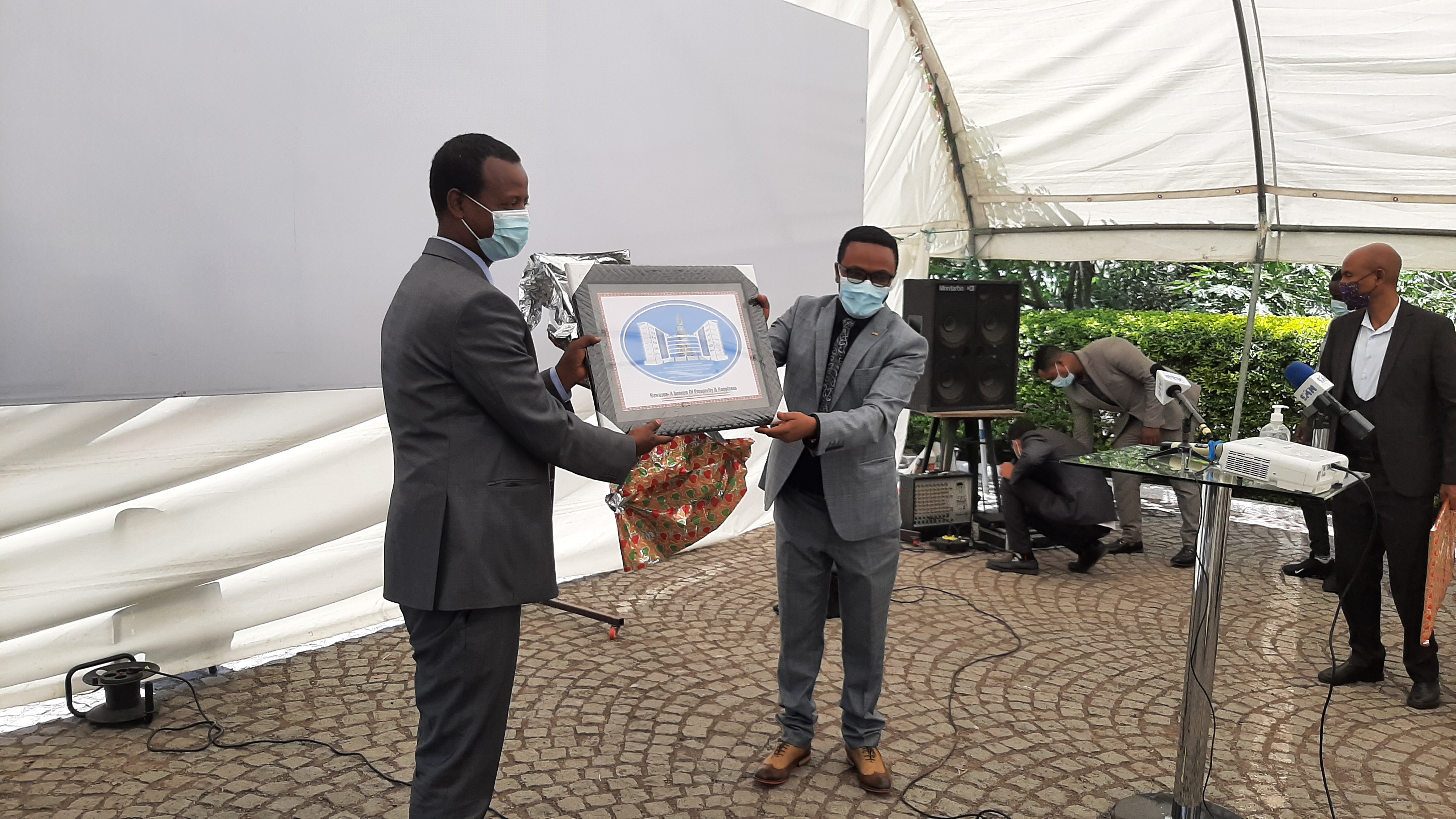 The Mayor of Hawassa, Tsegaye Tuke, hands over a plaque with the emblem of the city of Hawassa to Dr. Belay File of UN Habitat  as an appreciation for the partnership towards the revision of the  Hawassa City Structure Plan.