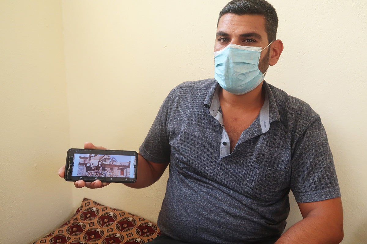 Omar showing a photo of his house damaged during the occupation of the militant group ISIL of Mosul City, Iraq in 2014