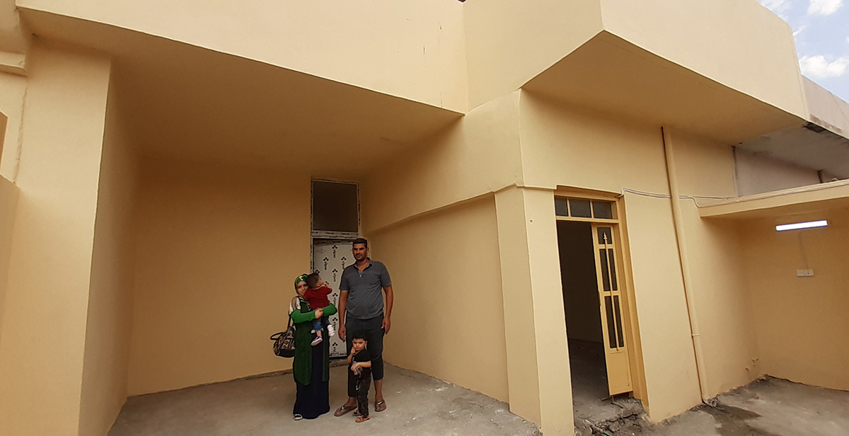 Omar and his family proudly standing in front of their newly rehabilitated house in Al-Shifaa neighbourhood of Mosul, Iraq as part of an EU-funded Programme