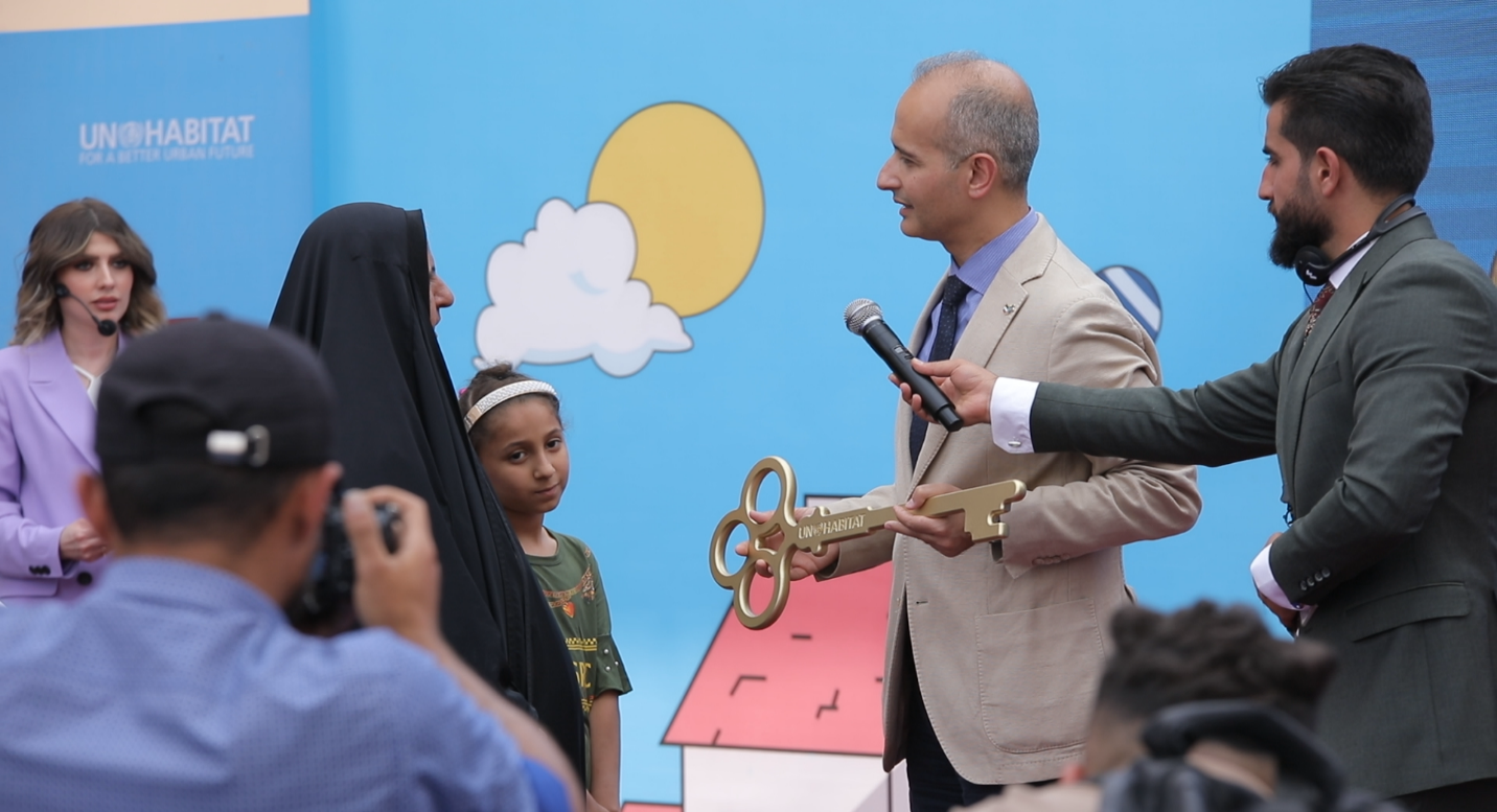 Erfan Ali, UN-Habitat Regional Representative for Arab States, hands a symbolic key to one of the recipients of the new houses in Bab Sinjar Housing Complex under UN-Habitat-Japan project