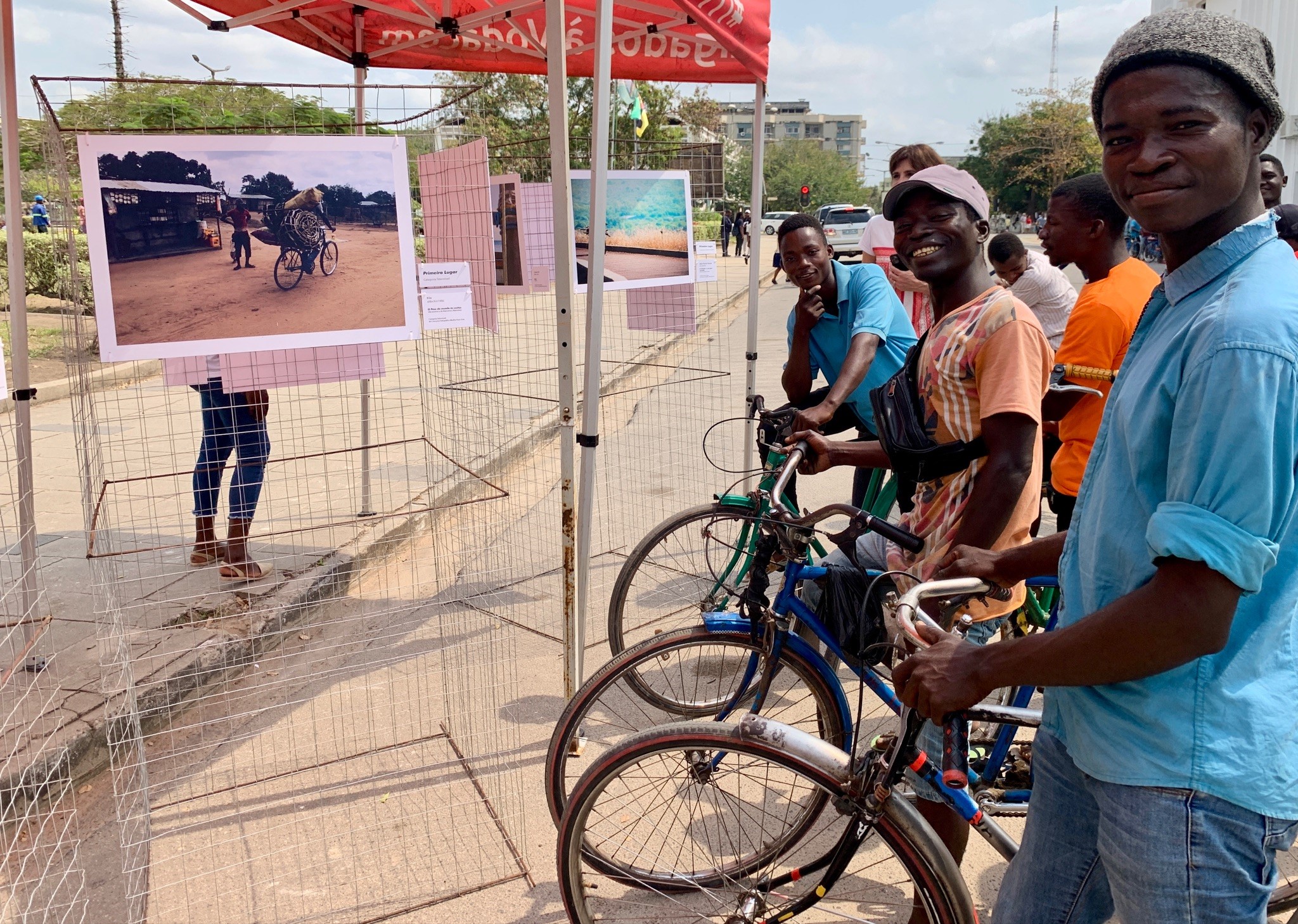 Cyclists posing while appreciating the road safety and active mobility photo exhibition at Quelimane’s Culture and Handcraft Fair. 