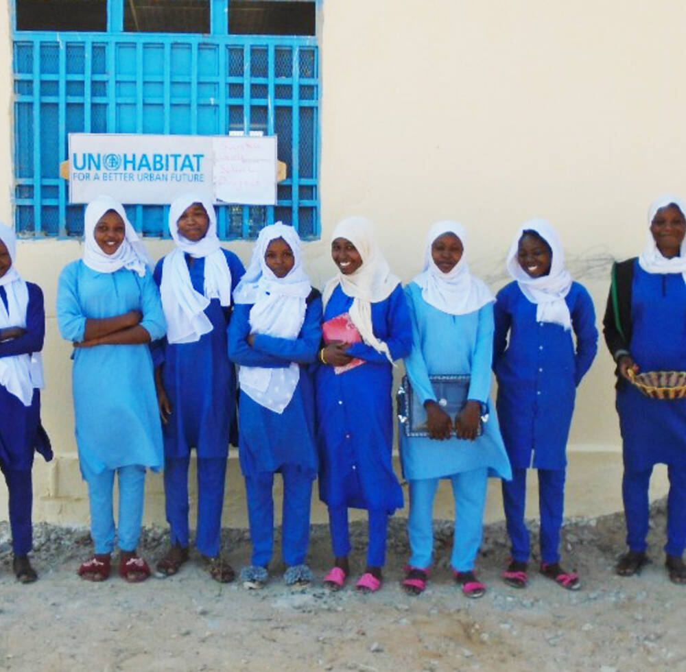 Girl students stand infront of the new school in Sunta, Darfur