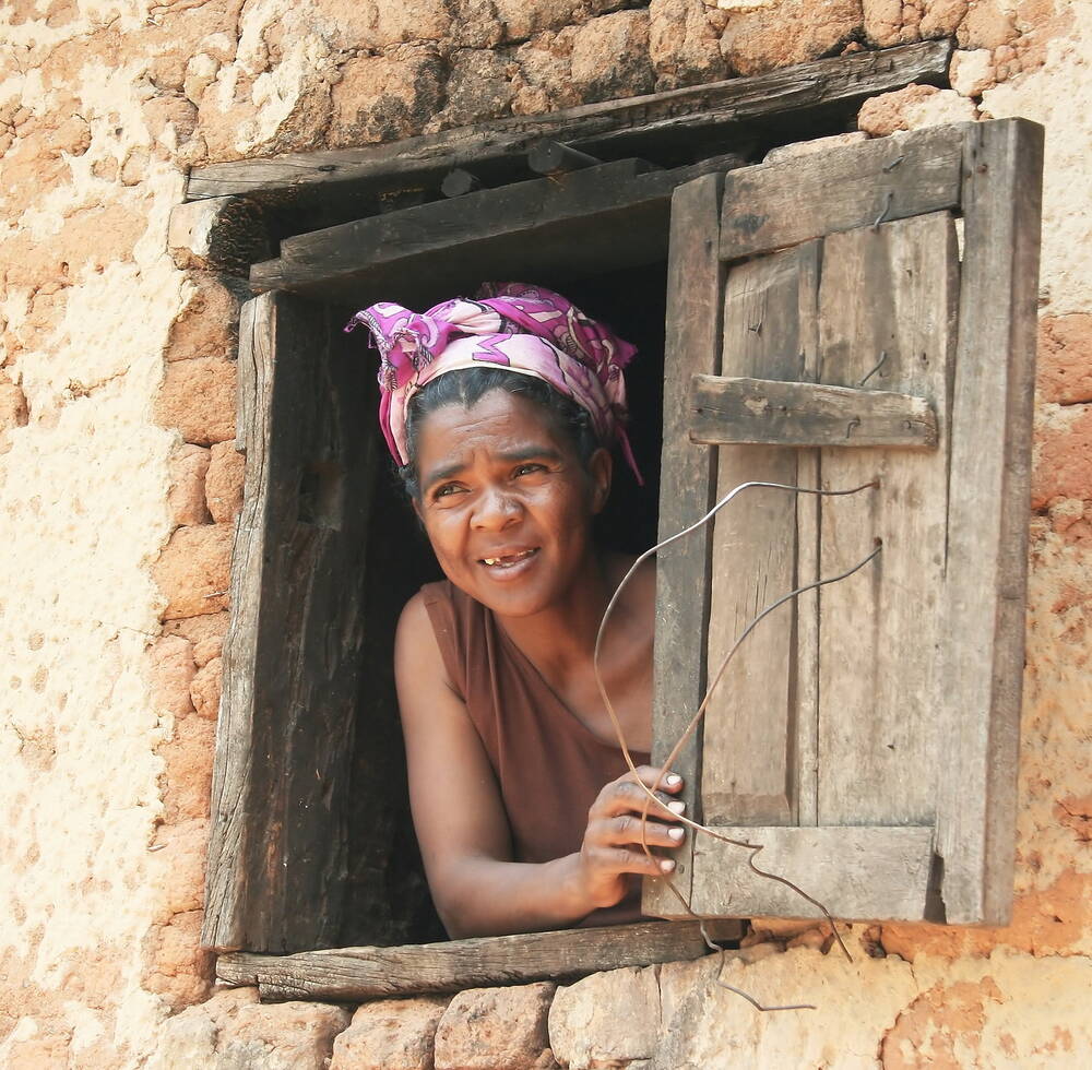 A woman peeps through a window in Madagascar. 2008.