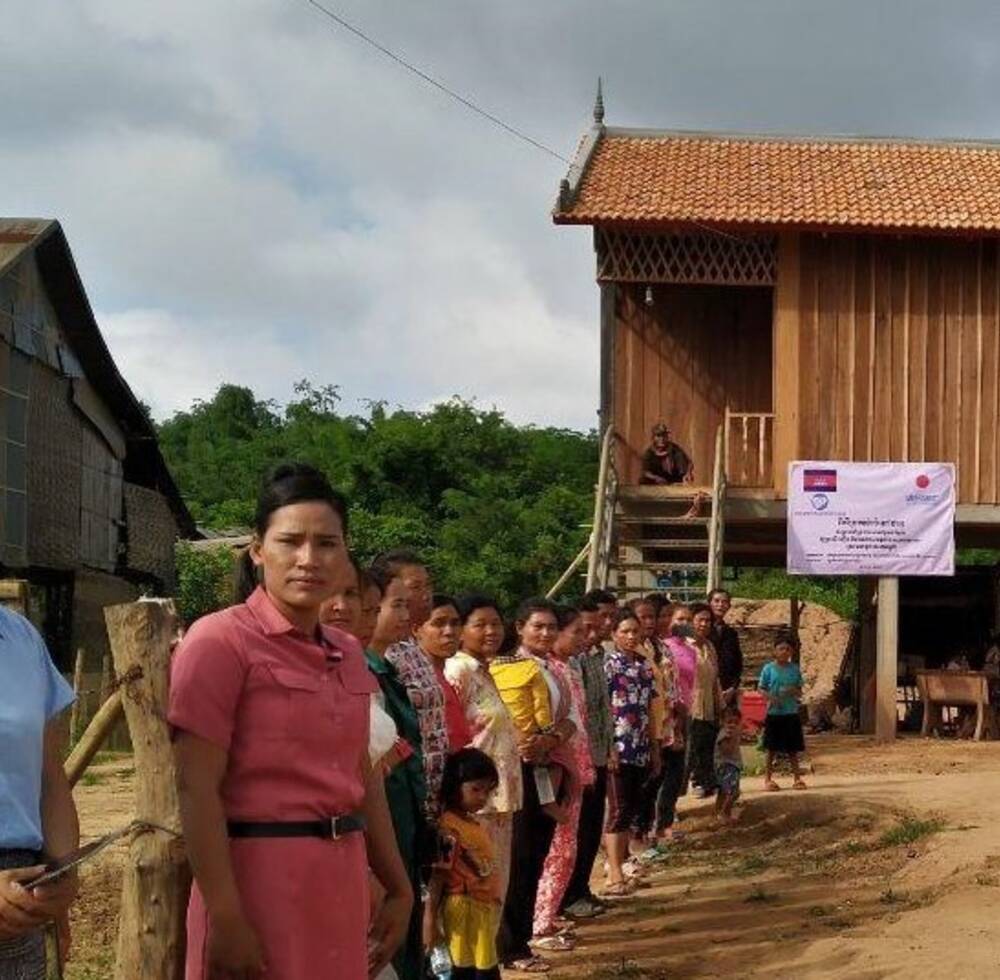 Families about to receive a new or rehabilitated house in Tboung Khmum, Cambodia welcome delegates to the official handover ceremony