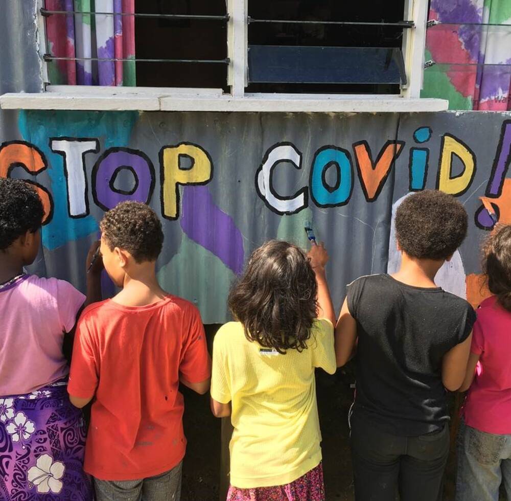 Young people in Vuniivi settlement, Lami, Fiji in front of their mural on COVID-19 prevention ©Katherine Drakeford