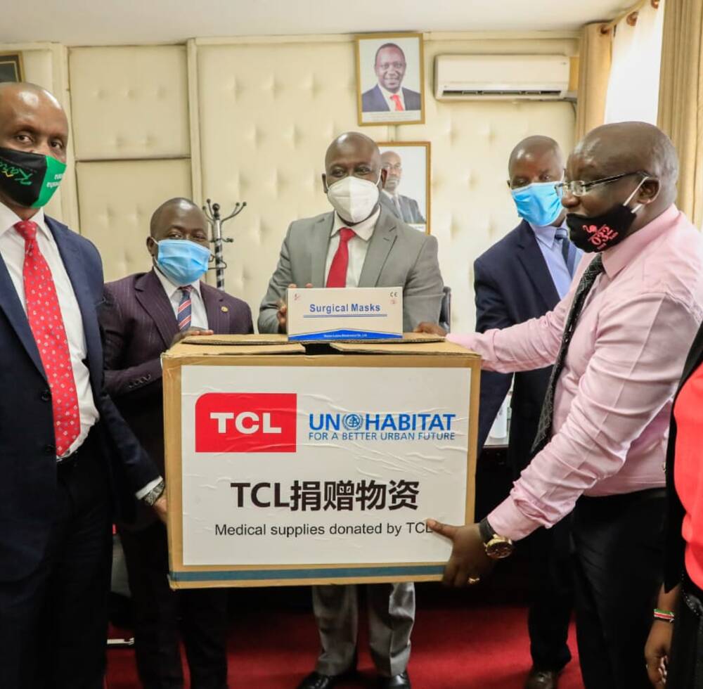 The Deputy Governor of Kenya’s Nakuru Municipality, Erick Korir, receives a donation of masks from UN-Habitat, provided by the TLC Foundation, for youth managing the eight new permanent wash facilities and community health volunteers