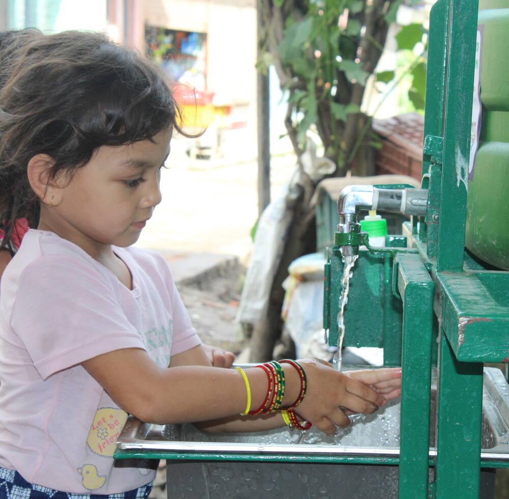 Children wash their hands to prevent the spread of COVID-19 in Bansighat, one of the informal settlements in Kathmandu, Nepal where UN-Habitat has installed touchless handwashing facilities