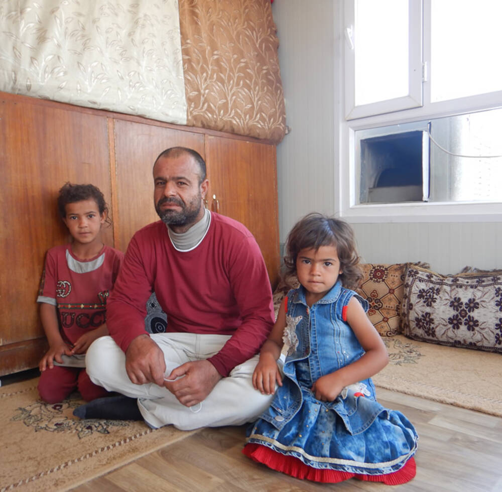 Former park squatter Suliman Hassan Matar and two of his children in their new home in Mosul, Iraq provided under an EU funded rehabilitation project run by UN-Habitat