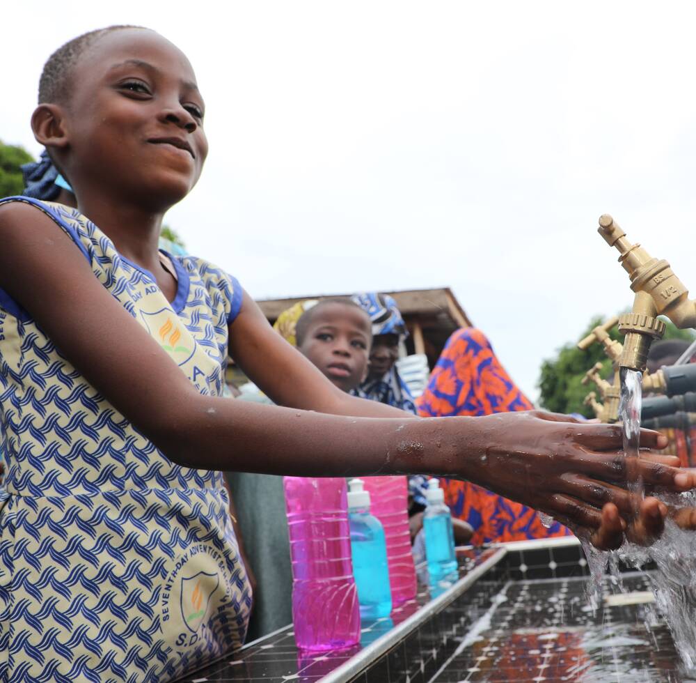 Residents of an informal settlement in Tamale, northern Ghana, receive clean water through hand washing stations and water tanks as a result of a project led by UN-Habitat, delivered 27 July 2021, to increase their ability to fight Covid-19.