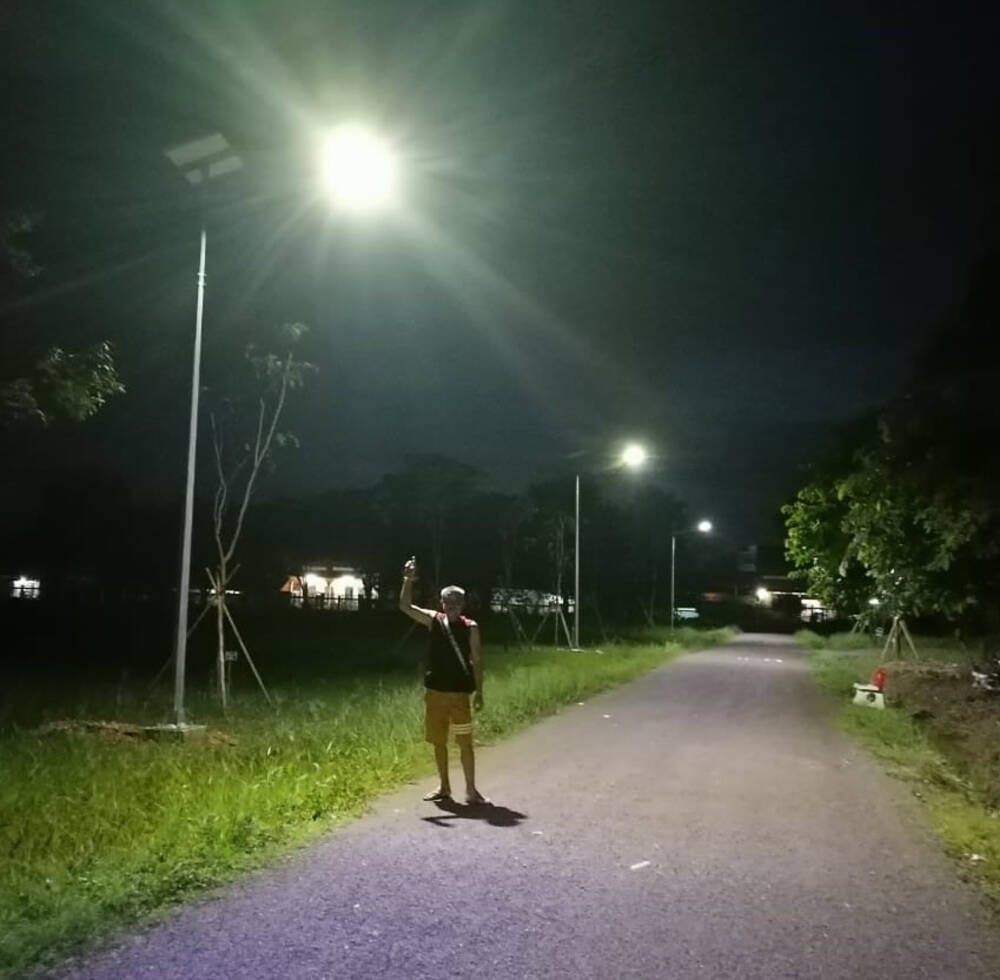 A local resident out for evening stroll enjoying the street lights in Pakse powered by 80W/18V Monocrystalline silicone cell solar panels as part of Urban LEDS II project