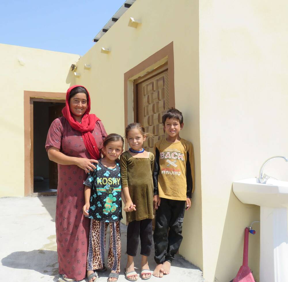 A Yazidi family in front of their rehabilitated house in Sinjar, Iraq, thanks to UN-Habitat.