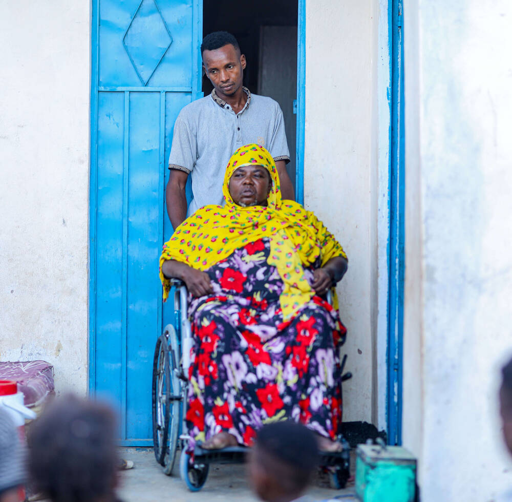 Mako Mohamud, whose newly acquired wheelchair has improved her mobility and independence, poses outside her permanent home in Gribble Settlement. © UN-Habitat