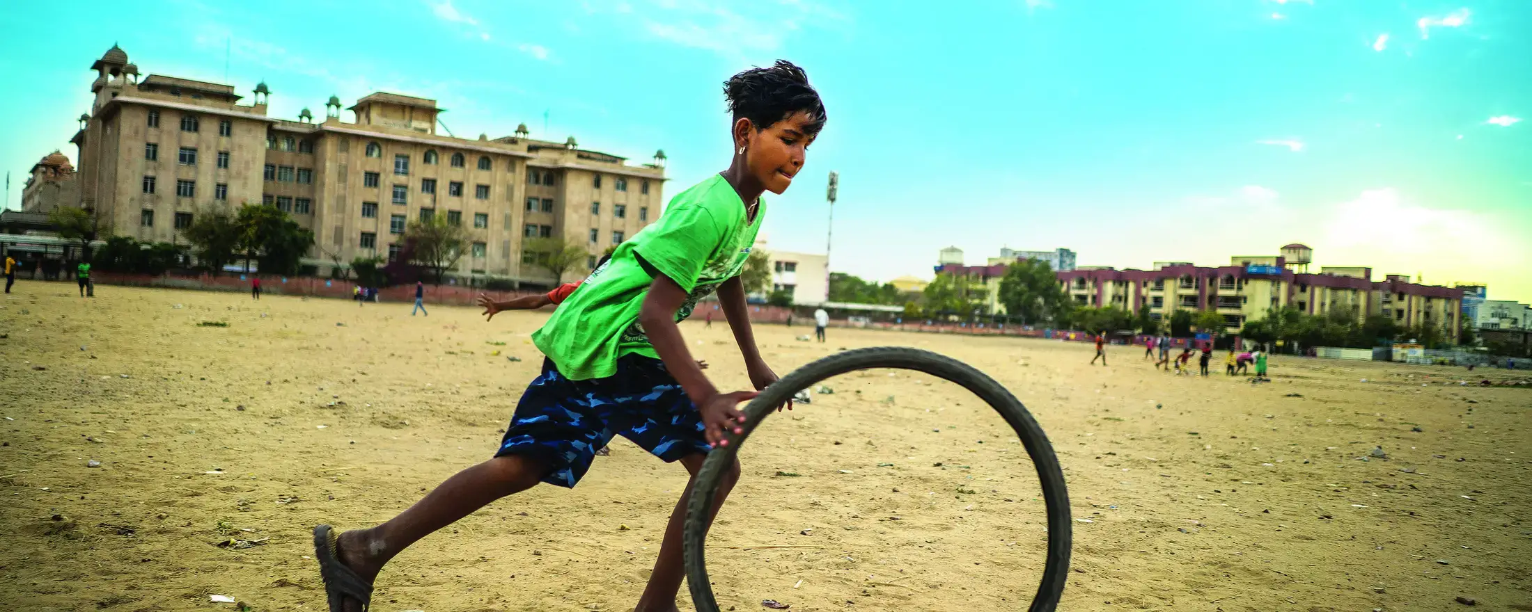 A girl play with a bycicle wheel