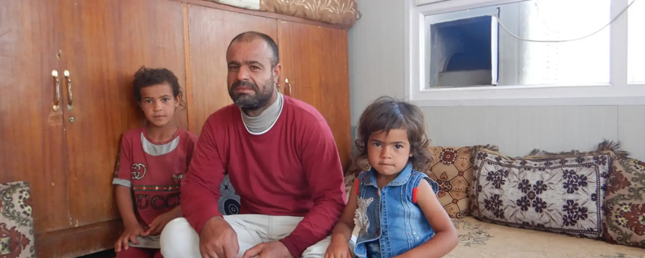 Former park squatter Suliman Hassan Matar and two of his children in their new home in Mosul, Iraq provided under an EU funded rehabilitation project run by UN-Habitat