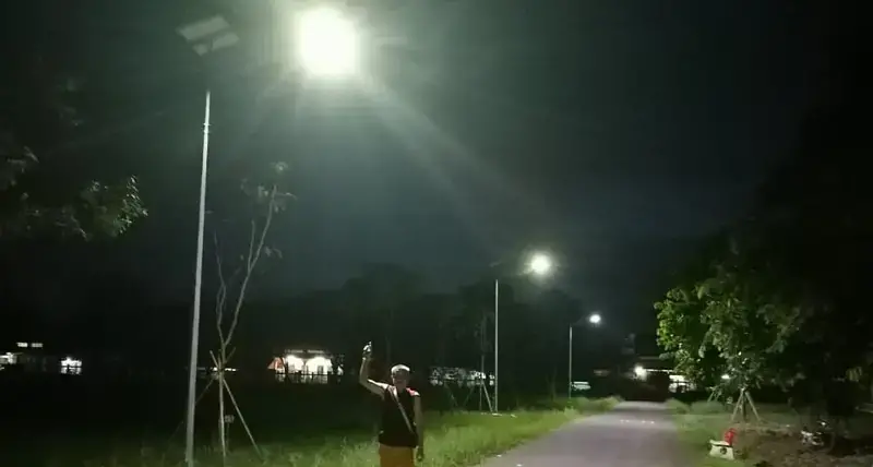 A local resident out for evening stroll enjoying the street lights in Pakse powered by 80W/18V Monocrystalline silicone cell solar panels as part of Urban LEDS II project